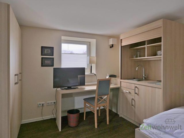 Blick zu Kleiderschrank und TV