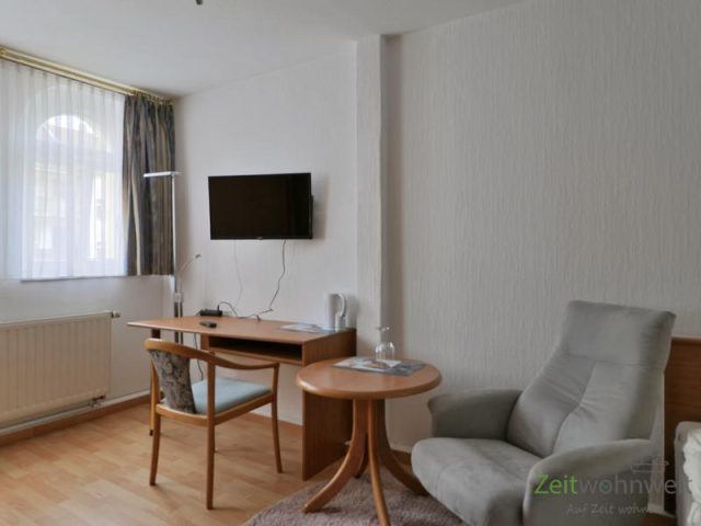 Sessel, TV und Schreibtisch